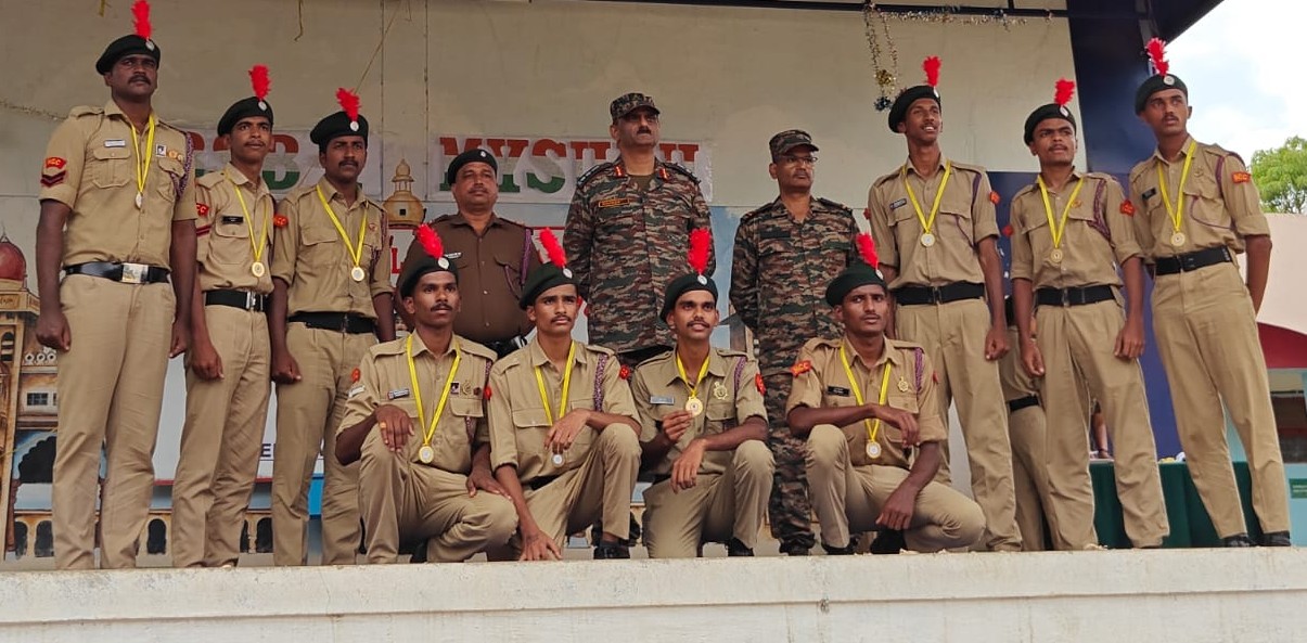 NCC cadets wearing medals with officers at a camp